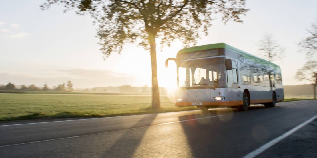 Üstra-Bus auf Strecke mit untergehender Sonne
